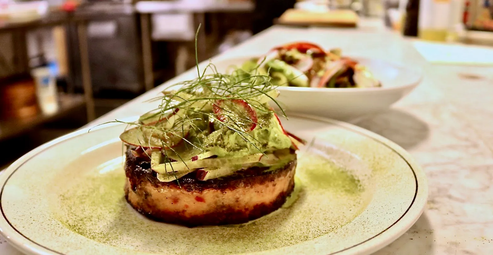 The Deer and The Dove signature dishes "The Bad Hombre" Burger, Seared Foie Gras, and seasonal game preparations like venison or duck.
